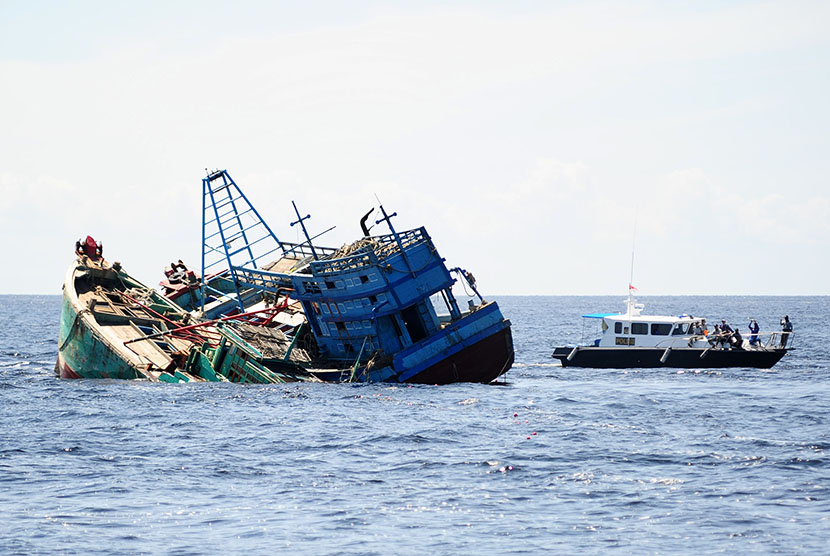 Kapal Polisi Air (Polair) berada di samping dua kapal motor nelayan Vietnam yang ditenggelamkan di Pulau Datuk, Kabupaten Mempawah, Kalbar, Selasa (5/4).  (Antara/Jessica Wuysang)