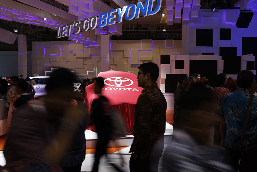 Pengunjung melintasi stan Toyota Sienta pada Indonesian International Motor Show (IIMS) 2016, Jakarta.