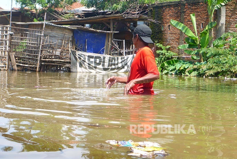 Seorang warga melintasi genangan banjir yang melanda kawasan Pejaten, Jakarta Selatan, Kamis (21/4).  (Republika/Yogi Ardhi)
