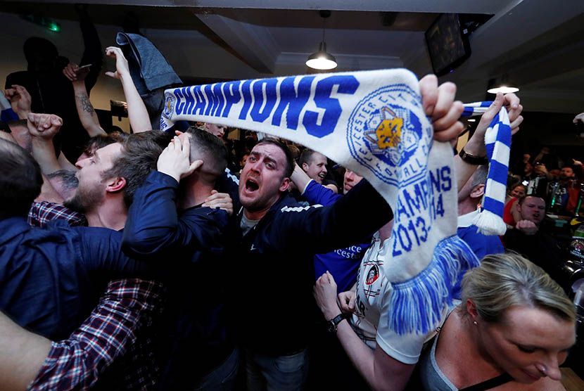 Suporter Leicester City merayakan keberhasilan tim kesayangan mereka yang berhasil meraih gelar Liga Primer Inggris.  (Reuters/Eddie Keogh)