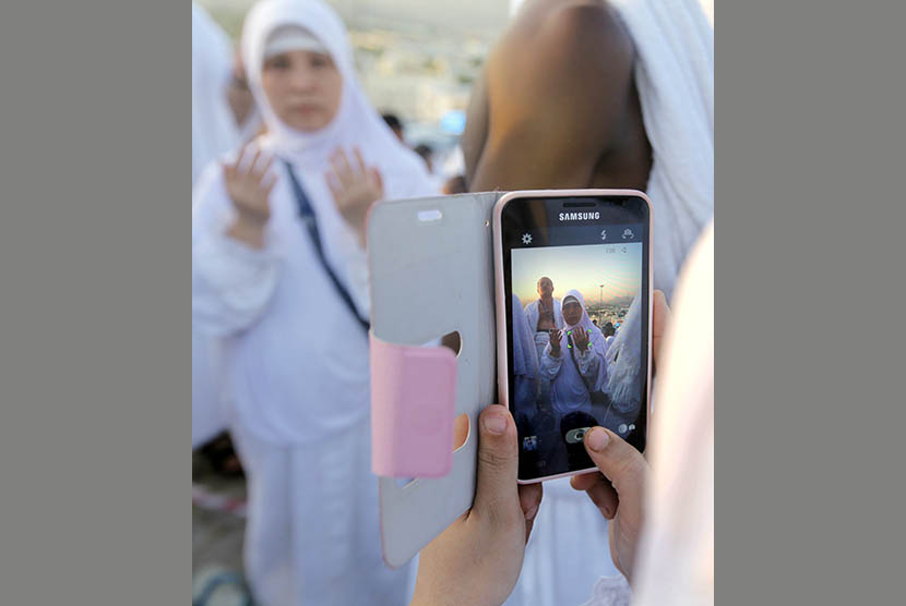 Ilustrasi jamaah melakukan foto selfie saat memakai pakaian umrah.