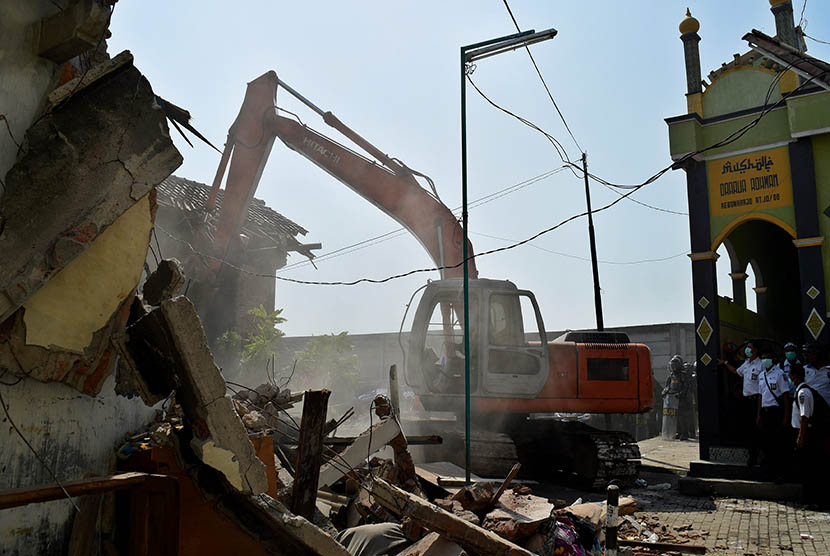 Petugas dengan bantuan alat berat merobohkan bangunan rumah saat dilakukan penggusuran puluhan rumah di kawasan Kebonharjo, Semarang, Jateng, Kamis (19/5). (Antara/R. Rekotomo)