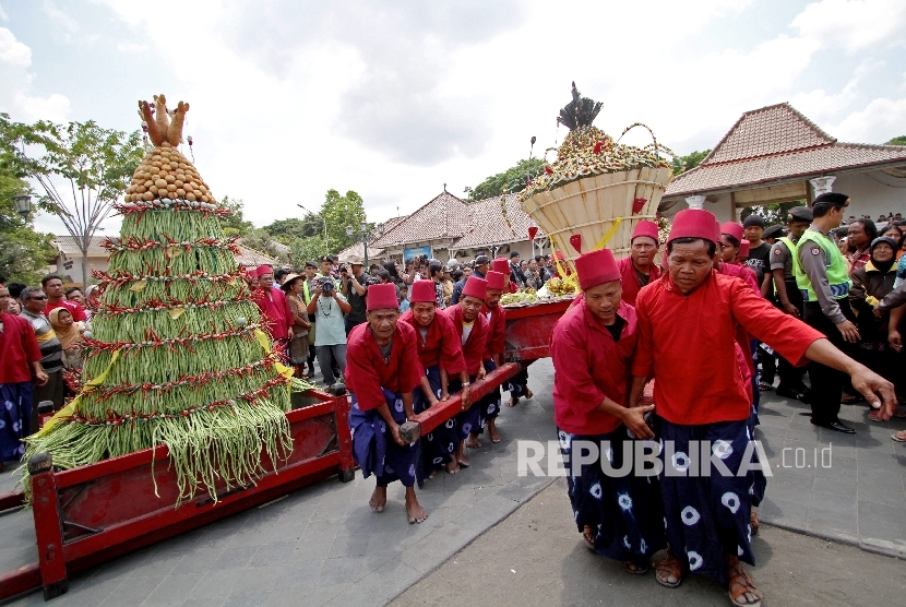  Abdi dalem Kraton Yogyakarta membawa gunungan untuk diperebutkan saat Grebeg Besar di halaman Masjid Gede, Kauman, Yogyakarta.