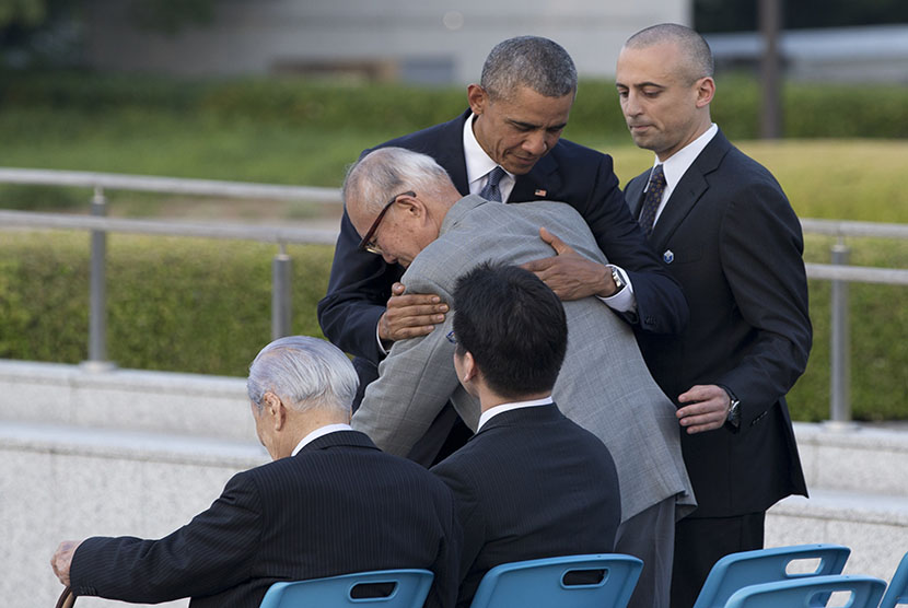   Presiden AS Barack Obama memeluk warga Jepang yang selamat dari serangan bom atom Shigeaki Mori, saat berkunjung ke Hiroshima Peace Memorial Park di Hiroshima, Jepang, Jumat (27/5). (AP/ Shuji Kajiyama)