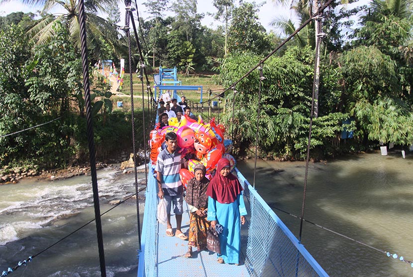 Warga melintas di atas jembatan gantung Gas Negara yang baru saja diresmikan di Kampung Amberang, Lebak, Banten, Jumat (3/6). (Antara/Reno Esnir)