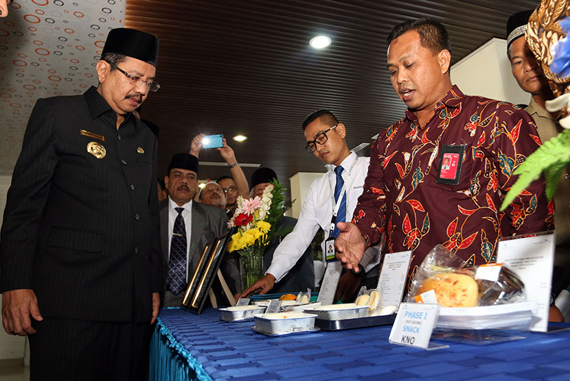 Gubernur Sumatra Utara, T Erry Nuradi (kiri) melihat paket makanan untuk jemaah calon haji selama dalam penerbangan, pada Meal Test di Asrama Haji Embarkasi Medan, Sumatra Utara, Selasa (26/7). (Antara//Irsan Mulyadi)