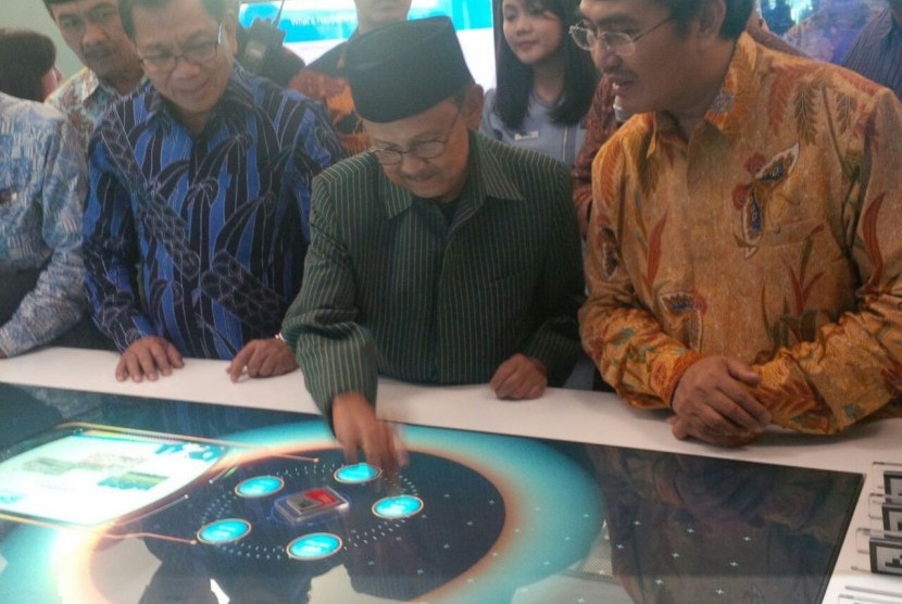 Mantan presiden BJ Habibie (tengah) sedang mencoba fasilitas smart table di outlet digital BRI di Bandara Internasional Soekarno-Hatta, Tangerang, Banten, Kamis (6/10).