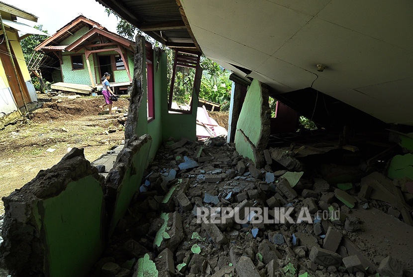 Seorang warga melintas di bagunan yang rusak akibat pergerakan tanah di Kampung Cikatomas, Sasak Gantung, Desa Citatah, Kecamatan Cipatat, Kabupaten Bandung Barat, Rabu (23/11). 