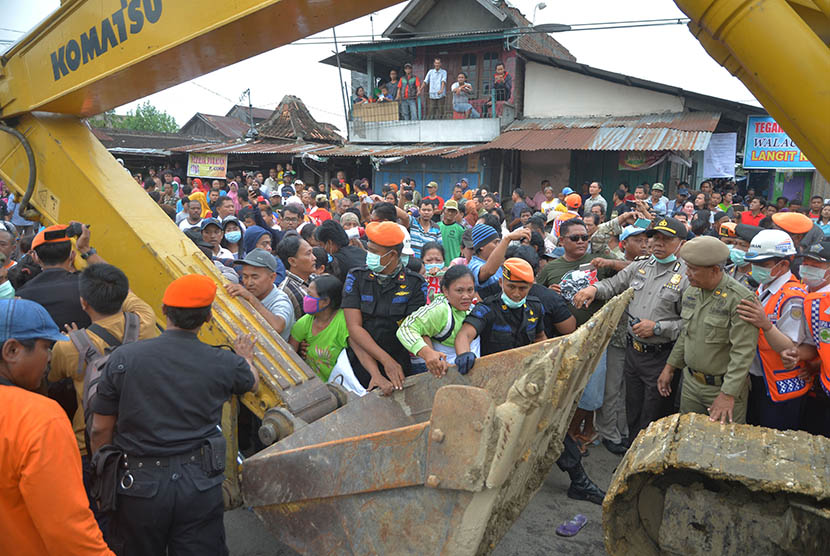 Warga menghadang alat berat saat pembongkaran permukiman liar yang menempati kawasan bekas Stasiun Purwodadi, Grobogan, Jawa Tengah, Kamis (22/12).