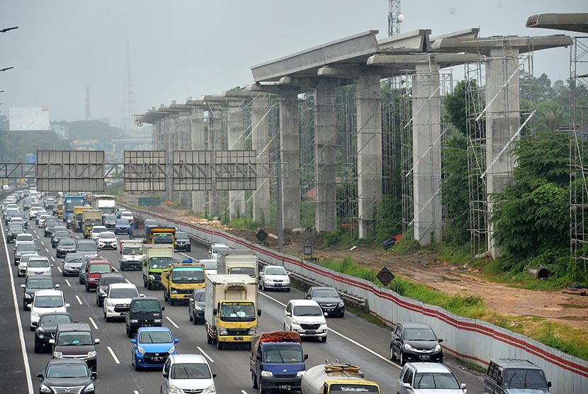 Kendaraan melintas di samping pembangunan  proyek Light Rail Transit (LRT) di Cibubur, Jaktim, Selasa (14/2). 