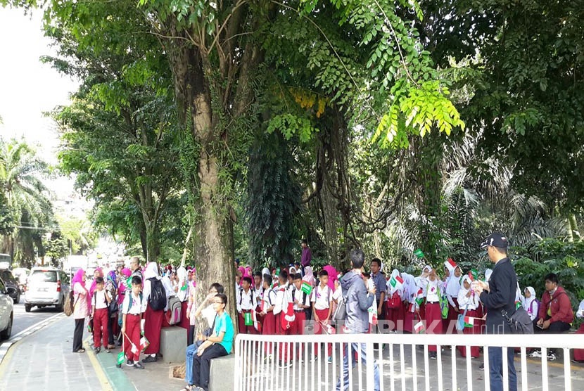 Pelajar Kota Bogor dengan bendera Indonesia-Arab Saudi disiapkan di jalur pedestrian Kebun Raya Bogor sejak pukul 10.00 WIB sambut Raja Salman, Rabu (1/3).