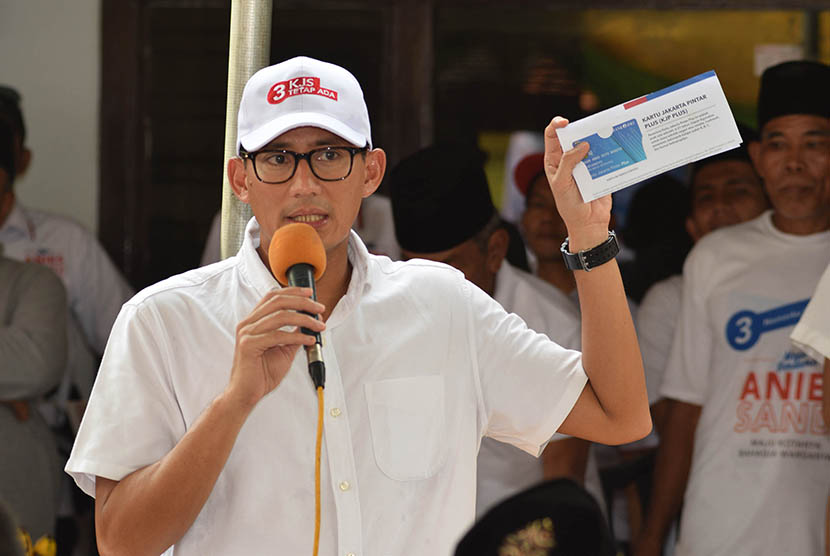 Calon Wakil Gubernur DKI Jakarta Sandiaga Uno menunjukan Kartu Jakarta Pintar (KJP) kepada warga Joglo, Jakarta Barat, Selasa (28/3).  