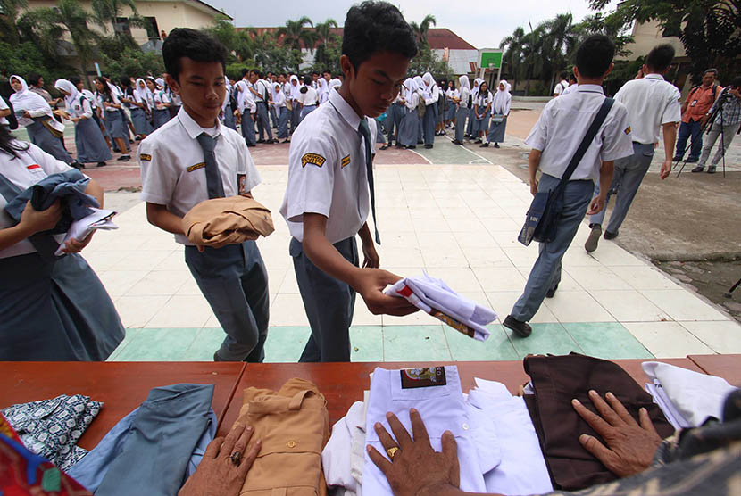 Sejumlah pelajar SMA menyumbangkan baju seragam sekolah mereka seusai pelaksanaan Ujian Nasional Berbasis Komputer (UNBK) hari terakhir di SMA Negeri 5 Medan, Sumatra Utara, Kamis (13/4).