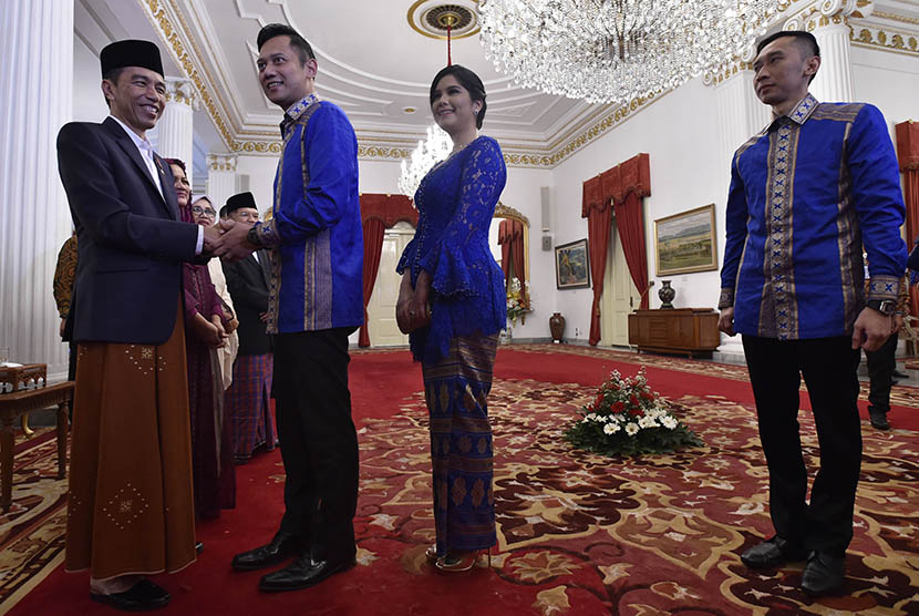 Presiden Joko Widodo (kiri) berjabat tangan dengan putra Presiden RI keenam Susilo Bambang Yudhoyono, Agus Harimurti Yudhoyono (kedua kiri) dan Edhie Baskoro Yudhoyono (kanan) beserta keluarga saat silaturahmi dan halalbihalal Hari Raya Idul Fitri 1438 Hijriah di Istana Negara, Jakarta, Ahad (25/6). 