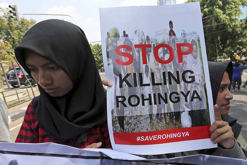  Salah seorang peserta aksi membawa poster yang mengutuk kebiadaban militer Myanmar terhadap warga Rohingya di depan Kedubes Myanmar, Jakarta, Jumat (8/9).
