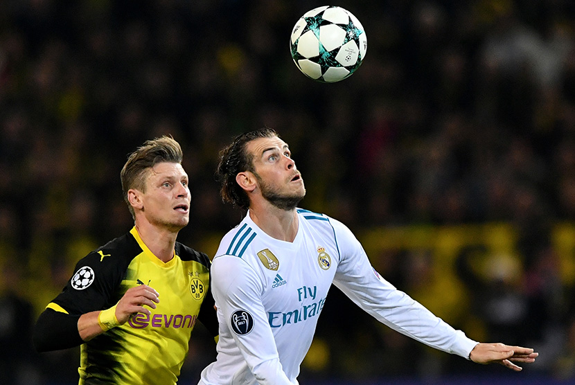  Pemain Real Madrid Gareth Bale (kanan) berebut bola dengan pemain Dortmund Lukas Piszczek  pada pertandingan grup H Liga Champions di Dortmund, Selasa (26/9).
