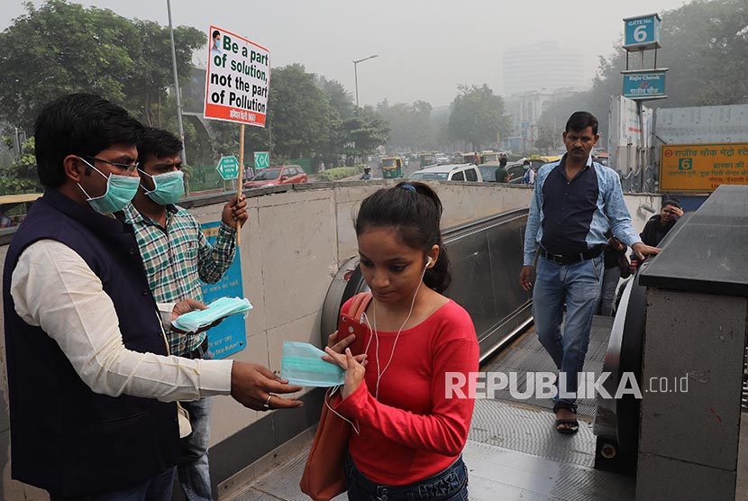  Relawan membagikan masker, saat asap dan polusi beracun yang melanda kota New Delhi, Kamis (9/11). 