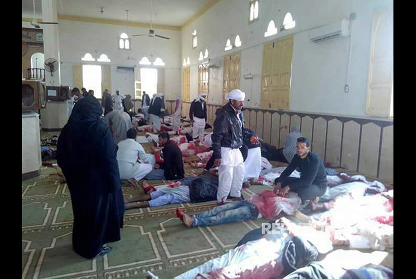  Orang-orang duduk di samping jenazah pemuja yang tewas dalam serangan di masjid di kota utara Arish, Semenanjung Sinai, Mesir, Jumat (24/11).