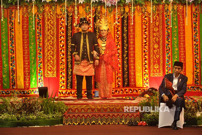 Presiden Joko Widodo (kanan) mengenakan sepatunya saat resepsi ngunduh mantu pernikahan putri dan menantunya Kahiyang Ayu-Bobby Afif Nasution di Medan, Sumatera Utara, Sabtu (25/11).