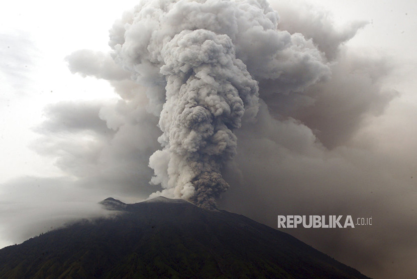 Pemandangan Gunung Agung saat memuntahkan asap dan abu vulkanis di Karangasem, Bali, Selasa (28/11).   