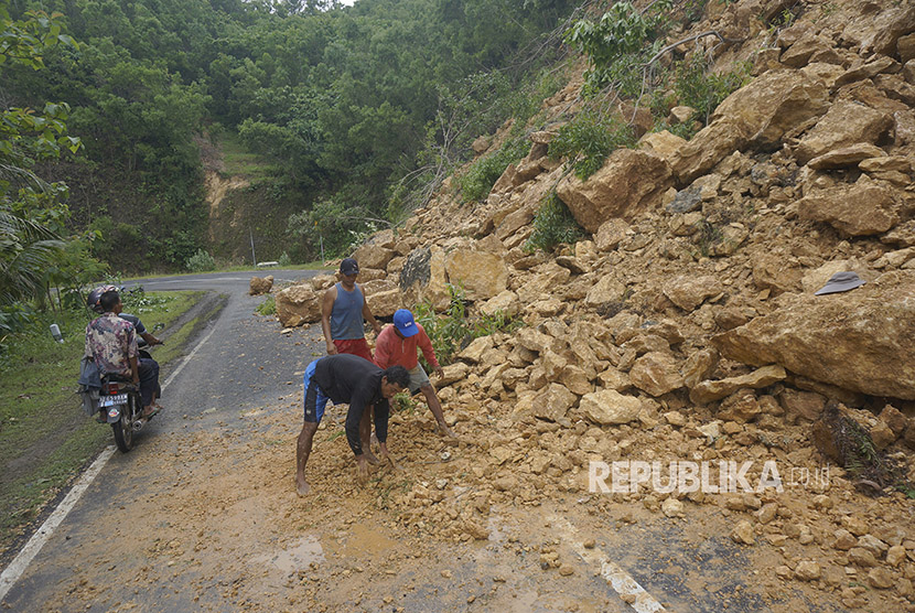 Warga menyingkirkan material longsor di jalur lintas selatan ((JLS) Pacitan, Jawa Timur, Rabu (29/11). 