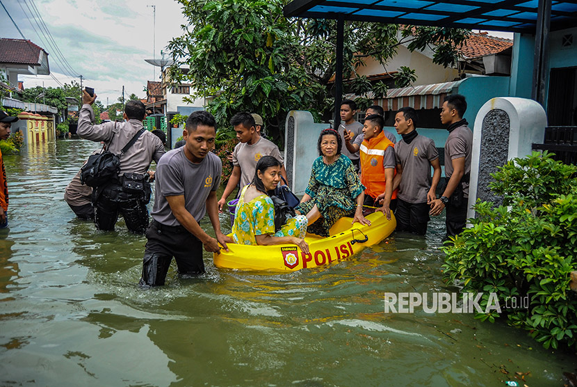 Petugas gabungan mengevakuasi warga terdampak banjir di Kecamatan Pekalongan Utara, Jawa Tengah, Jumat (1/12). 