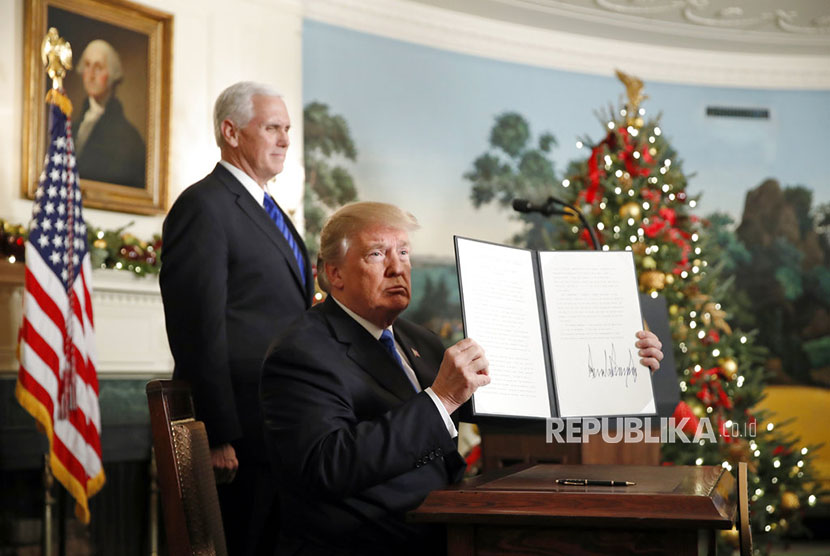 US President Donald Trump, accompanied by Vice President Mike Pence, holds up a signed proclamation recognizing Jerusalem as the capital of Israel in the Diplomatic Reception Room of the White House, Wednesday (Dec. 6), in Washington.