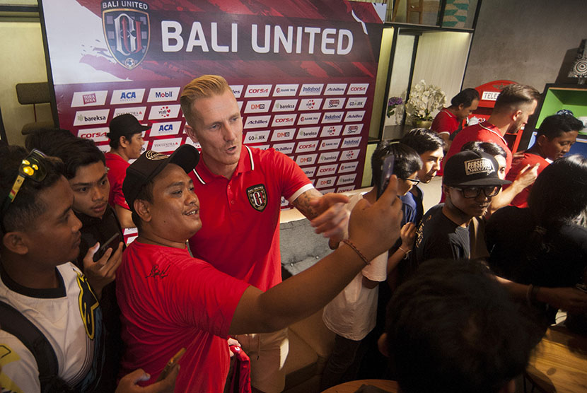 Pemain baru Bali United, Nick Van Der Velden (tengah) berfoto dengan para pendukung klub sepak bola itu seusai perkenalan pemain baru di Denpasar, Kamis (14/12).