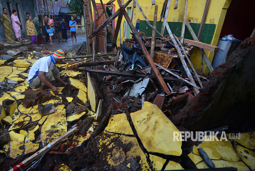 Warga membersihkan material reruntuhan bangunan rumah pasca gempa bumi di Desa Sumelap, Kota Tasikmalaya, Jawa Barat, Sabtu (16/12). 