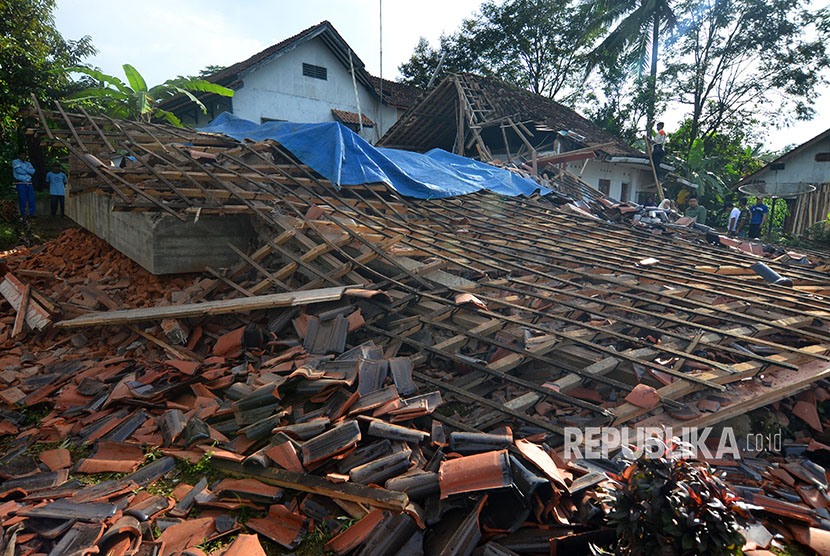 Warga menyaksikan rumah permanen berlantai dua yang ambruk akibat gempa bumi di Desa Gunung Sari, Jawa Barat, Sabtu (16/12).