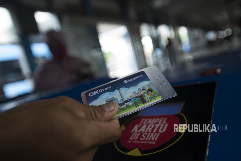 Warga menggunakan kartu One Karcis One Trip (OK Otrip) di hari pertama ujicoba sistem untuk program OK Otrip di halte transjakarta Harmoni, Jakarta, Jumat (22/12).