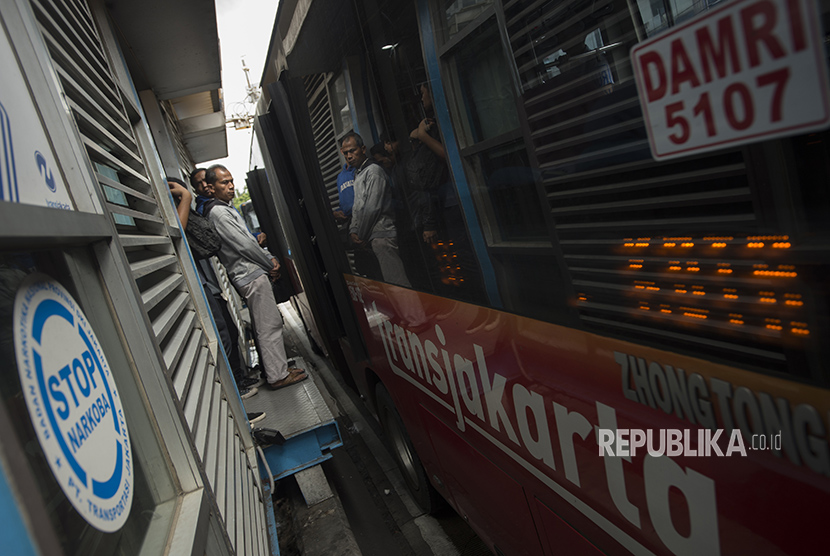 Warga menunggu moda angkutan transjakarta di hari pertama ujicoba sistem untuk program OK Otrip di halte transjakarta Harmoni, Jakarta, Jumat (22/12).