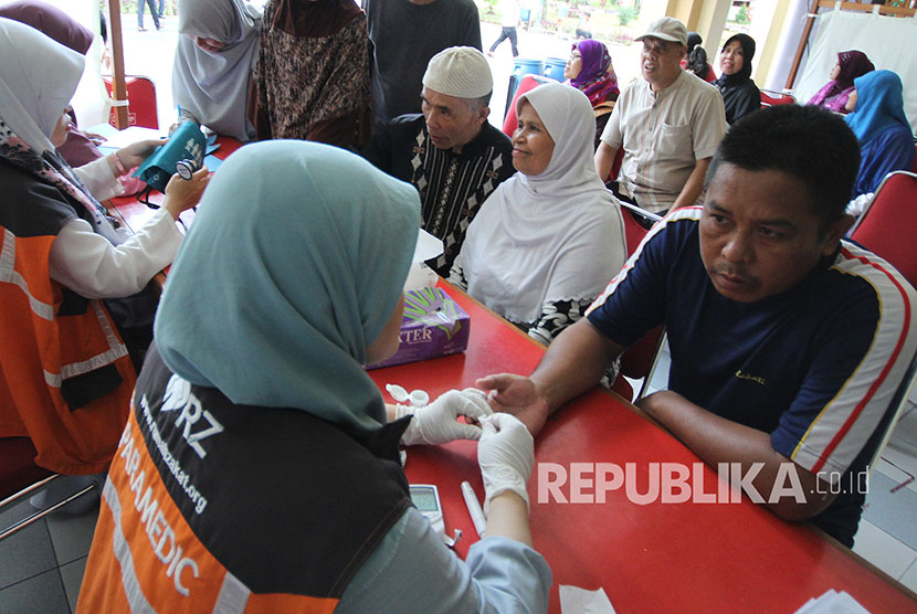 Pengunjung melakukan pemeriksaan darah oleh tim Rumah Zakat dalam rangkaian kegiatan Muhasabah Akhir Tahun bersama Republika, di Masjid Pusdai, Kota Bandung, Ahad (31/12).