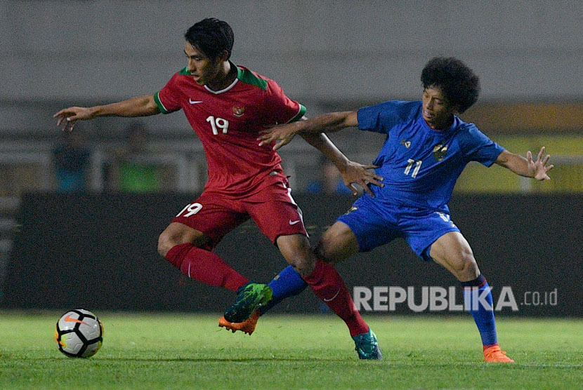  Pemain Timnas Indonesia U-23 Hanif Sjahbandi (kiri) menggiring bola dibayangi pemain Timnas Thailand U-23 Tanasith Siripala dalam pertandingan uji coba di Stadion Pakansari, Cibinong, Bogor, Jawa Barat, Ahad (3/6) malam.