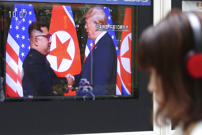 Seorang pria menonton layar TV yang menyiarkan pertemuan  Presiden AS Donald Trump dengan pemimpin Korea Utara Kim Jong Un di Seoul Railway Station di Seoul, Korea Selatan, Selasa (12/6).