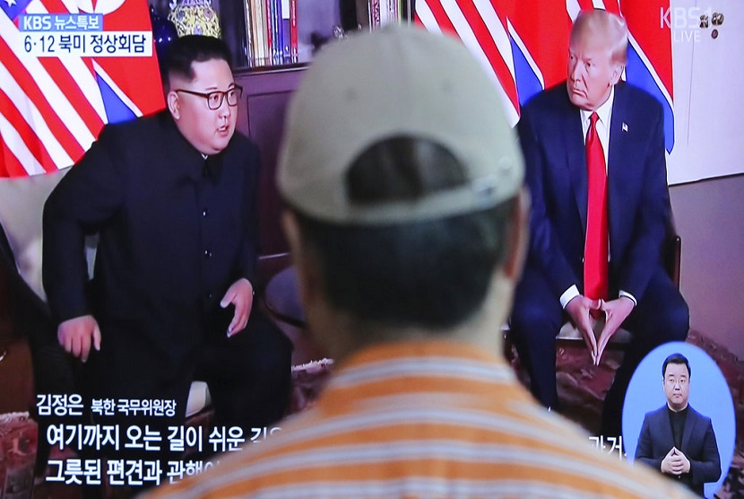  Seorang pria menonton layar TV yang menyiarkan pertemuan  Presiden AS Donald Trump dengan pemimpin Korea Utara Kim Jong Un di Seoul Railway Station di Seoul, Korea Selatan, Selasa (12/6).