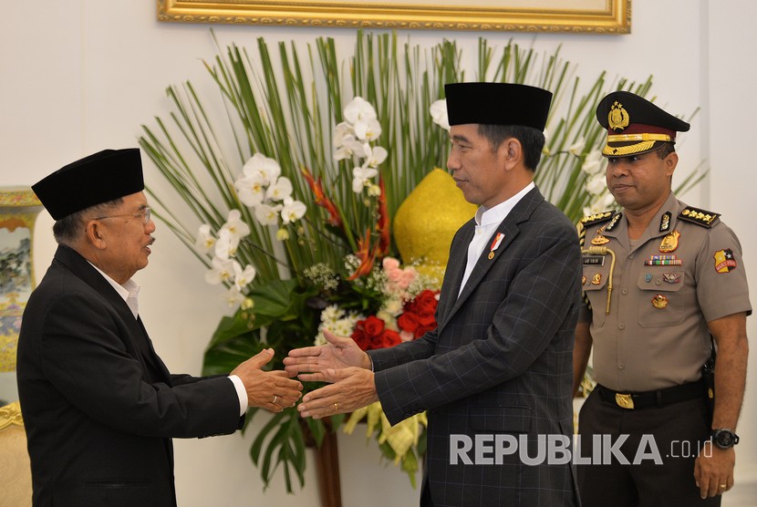 Presiden Joko Widodo (kedua kanan) berjabat tangan dengan Wakil Presiden Jusuf Kalla (kiri) di acara Silahturahmi Idul Fitri 1 Syawal 1439 H di Istana Kepresidenan Bogor, Jawa Barat, Jumat (15/6). 