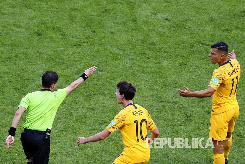 Pesepa bola Australia memprotes wasit asal Uruguay Andres Cunha (kiri) yang menunjuk titik penalti.
