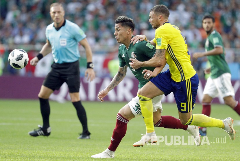  Pesepak bola Swedia Marcus Berg berebut bola dengan pesepak bola Meksiko  Carlos Salcedo pada pertandingan grup F Piala Dunia 2018 di Yekaterinburg Arena, Rabu (27/6). 