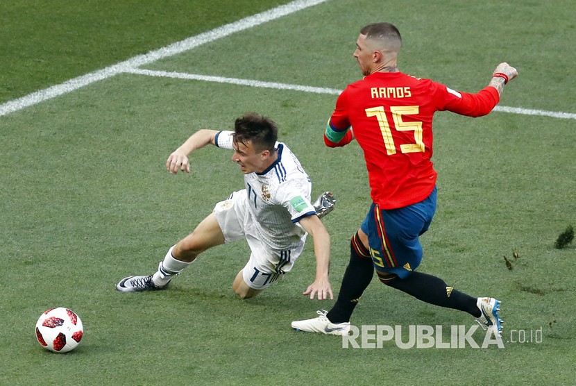  Pesepak bola Sergio Ramos berebut bola dengan pesepak bola Rusia Alexander Golovin pada pertandingan babak 16 besar Piala Dunia 2018 antara Rusia melawan Spanyol, di Stadion Luzhinik, Moskow, Ahad (1/7).