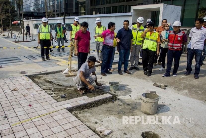 Gubernur DKI Jakarta Anies Baswedan (tengah) meninjau pembangunan trotoar di Jalan Sudirman, Jakarta, Ahad (22/7). 