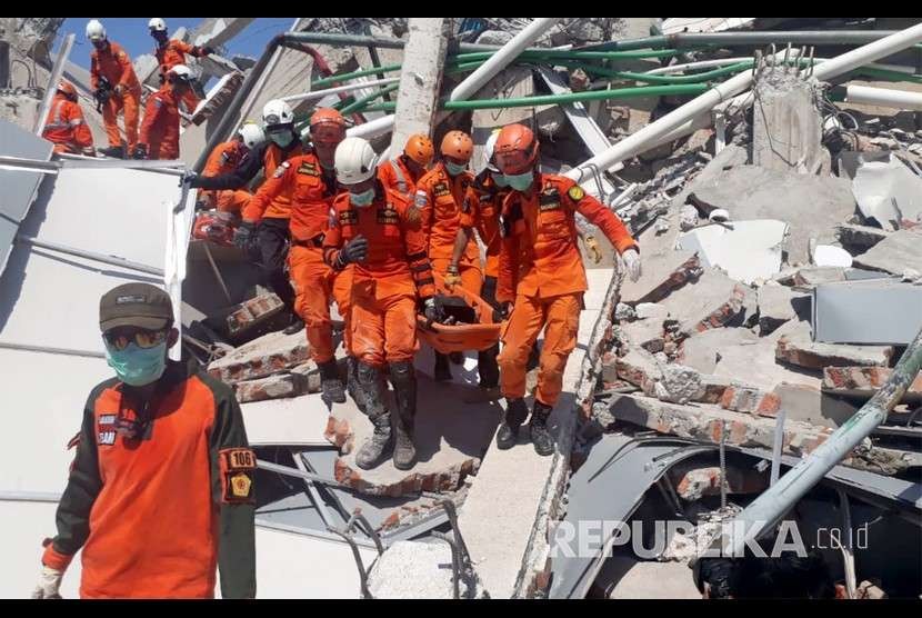  Tim SAR melakukan evakuasi korban gempa yang tertimbun reruntuhan bangunan hotel Roa-Roa di Palu, Ahad (30/9).