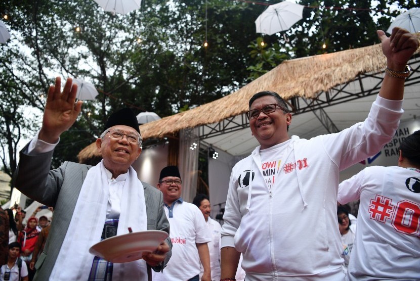 Cawapres nomor urut 01 Ma'ruf Amin (kiri) didampingi SekretarisTim Kampanye Nasional Hasto Hasto Kristiyanto melambaikan tangan seusai meluncurkan Rumah Aspirasi Rakyat #01 di Menteng, Jakarta Pusat, Ahad (4/11).