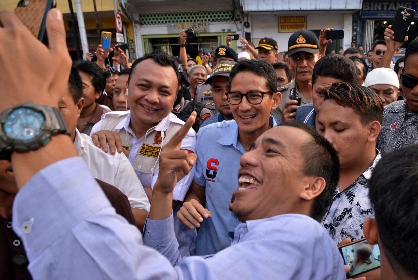 Relawan berfoto bersama Calon Wakil Presiden nomor urut 02 Sandiaga Uno (tengah) saat berkunjung di kawasan kuliner Jalan Roda, Manado, Sulawesi Utara, Senin (5/11/2018). 