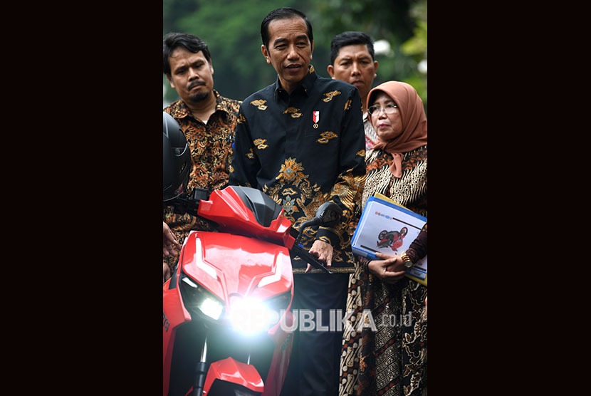 Presiden Joko Widodo bersiap menjajal motor listrik buatan dalam negeri Gesits seusai melakukan audiensi dengan pihak-pihak yang terlibat proses produksi di halaman tengah Istana Kepresidenan, Jakarta, Rabu (7/11/2018).