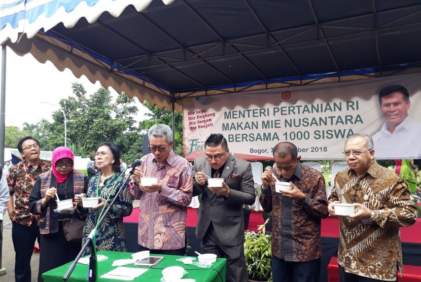 Kepala Balitbangtan Muhammad Syakir, Wakil Ketua Komisi IV DPR RI Michael  Wattimena dan Kepala Badan Ketahanan Pangan Agung Hendriadi (tiga di  tengah) memakan mie non gandum pada acara Pangan Lokal Fiesta di  Auditorium Sadikin  Sumintawikarta, Kampus Pertanian Cimanggu, Bogor, Rabu (7/11).