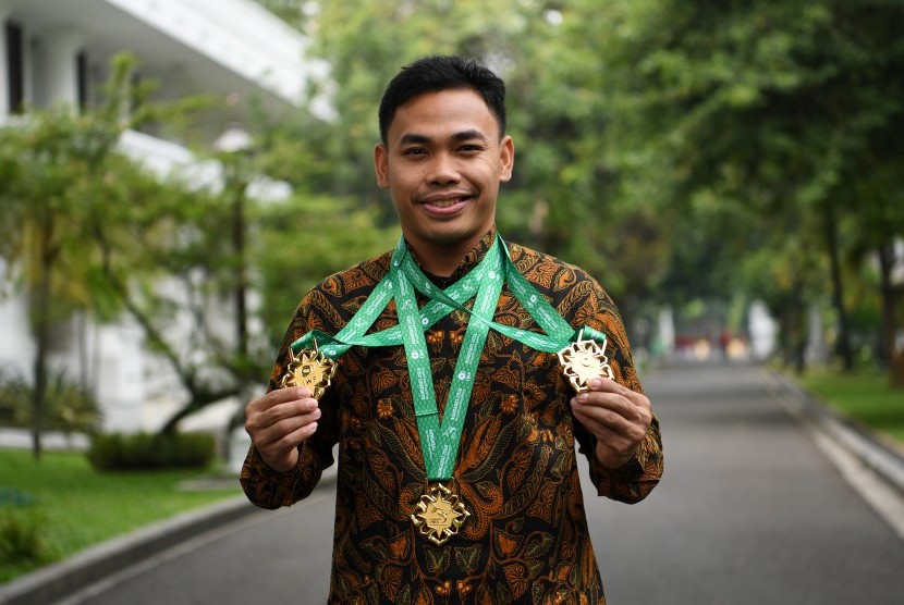 Lifter Eko Yuli Irawan memperlihatkan medali seusai diterima oleh Presiden Joko Widodo di Kompleks Istana Kepresidenan, Jakarta, Kamis (8/11/2018). 