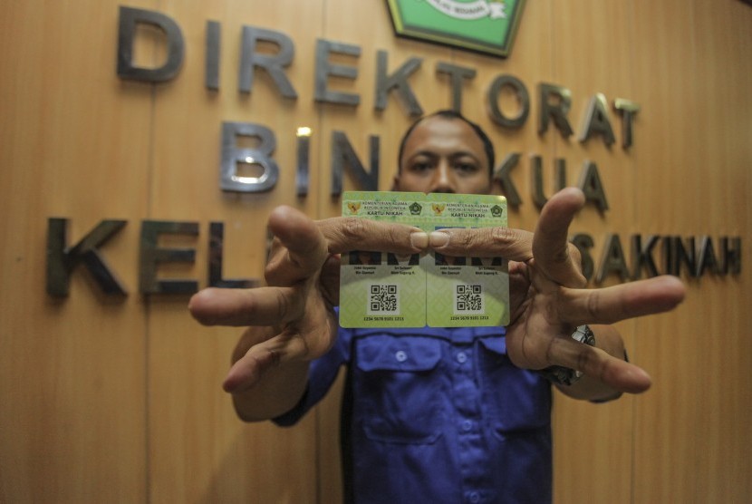 Petugas Kementerian Agama (Kemenag) menunjukkan Kartu Nikah di kantor Kemenag, Jakarta, Senin (12/11/2018)