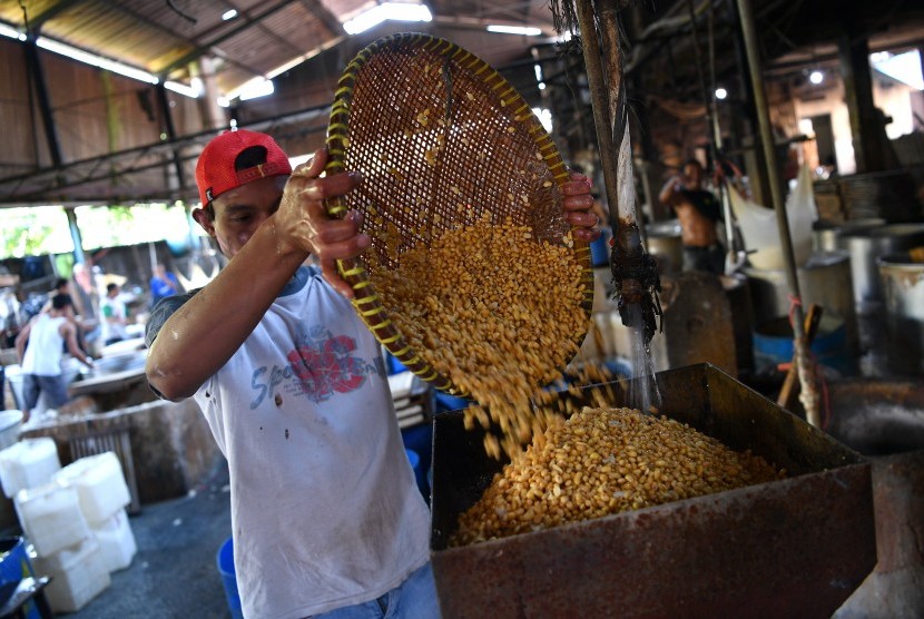 Pekerja menggiling kedelai impor untuk diolah menjadi tahu. Kedelai menjadi salah satu bahan baku penyumbang impor pada Juli 2019