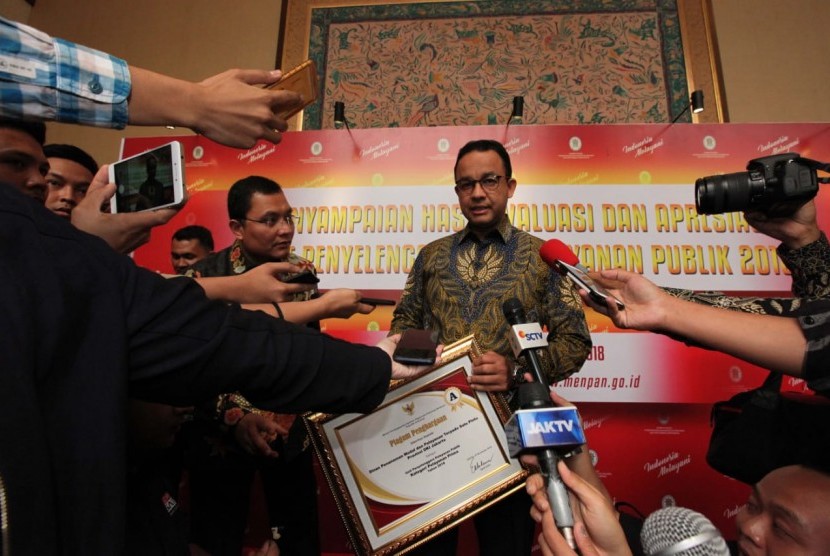 Gubernur DKI Jakarta, Anies Baswedan (kanan) dan Kepala DPMPTSP Provinsi DKI Jakarta, Edy Junaedi usai menerima penghargaan sebagai Unit Penyelenggara Pelayanan Publik Kategori Pelayanan Prima (Nilai A) dari Kemen PANRB, Selasa (27/11).